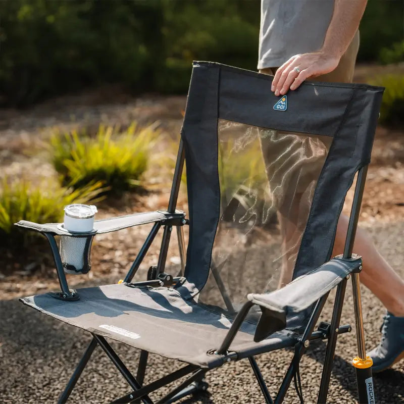 Close-up of the Heathered Charcoal Comfort Pro Rocker XL with a mesh back and drink in the cupholder.