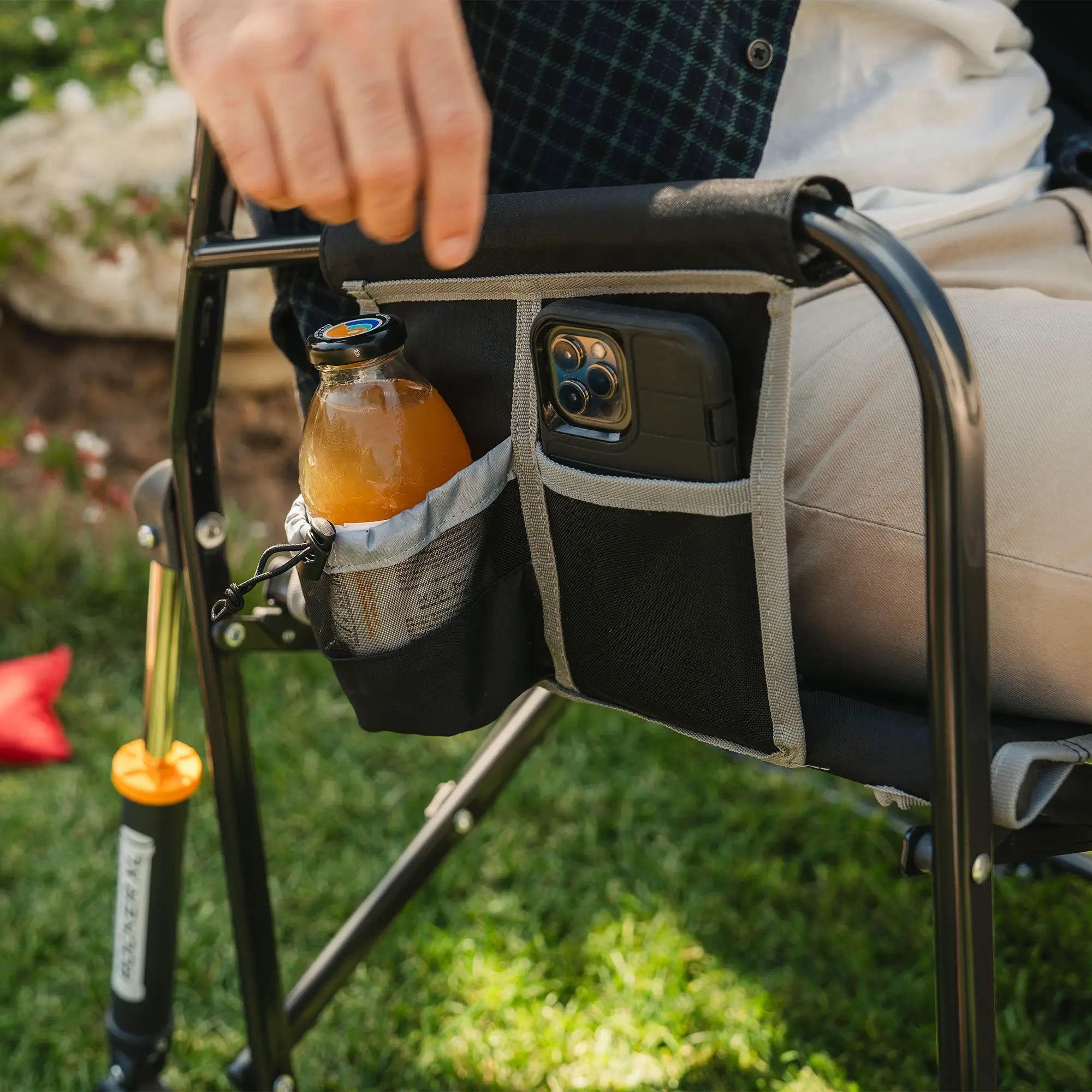 An up-close angle of the side pocket on the black freestyle rocker xl showing a phone pocket and drink holder.