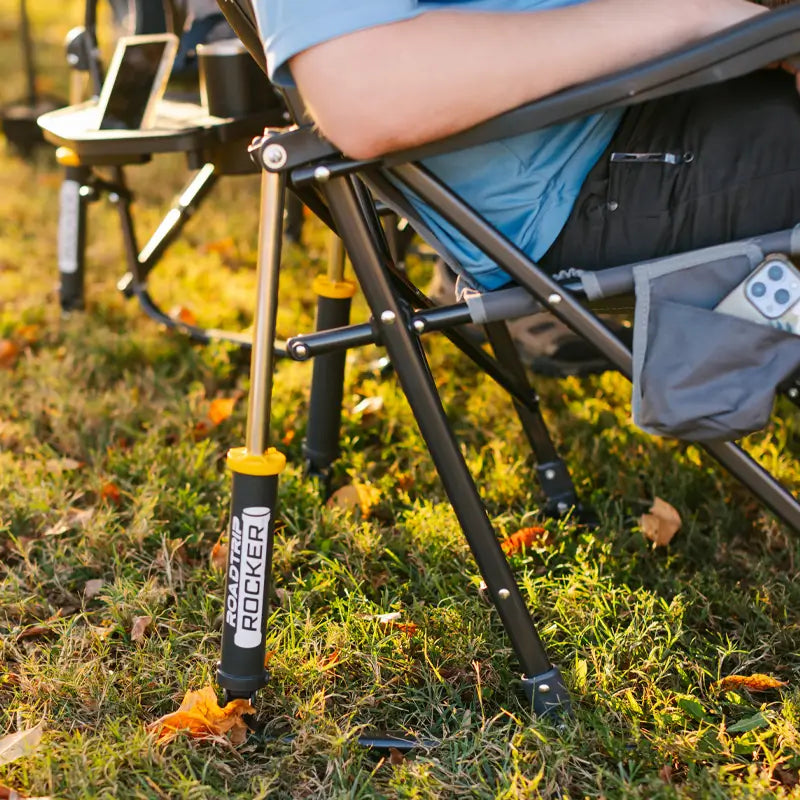 Close-up of Roadtrip Rocker leg and spring on green grass with autumn leaves.
