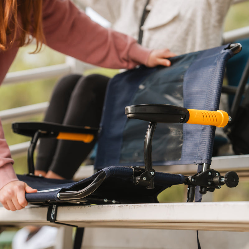 Rich blue Stadium Rock-Cliner being placed and adjusted on bleachers.