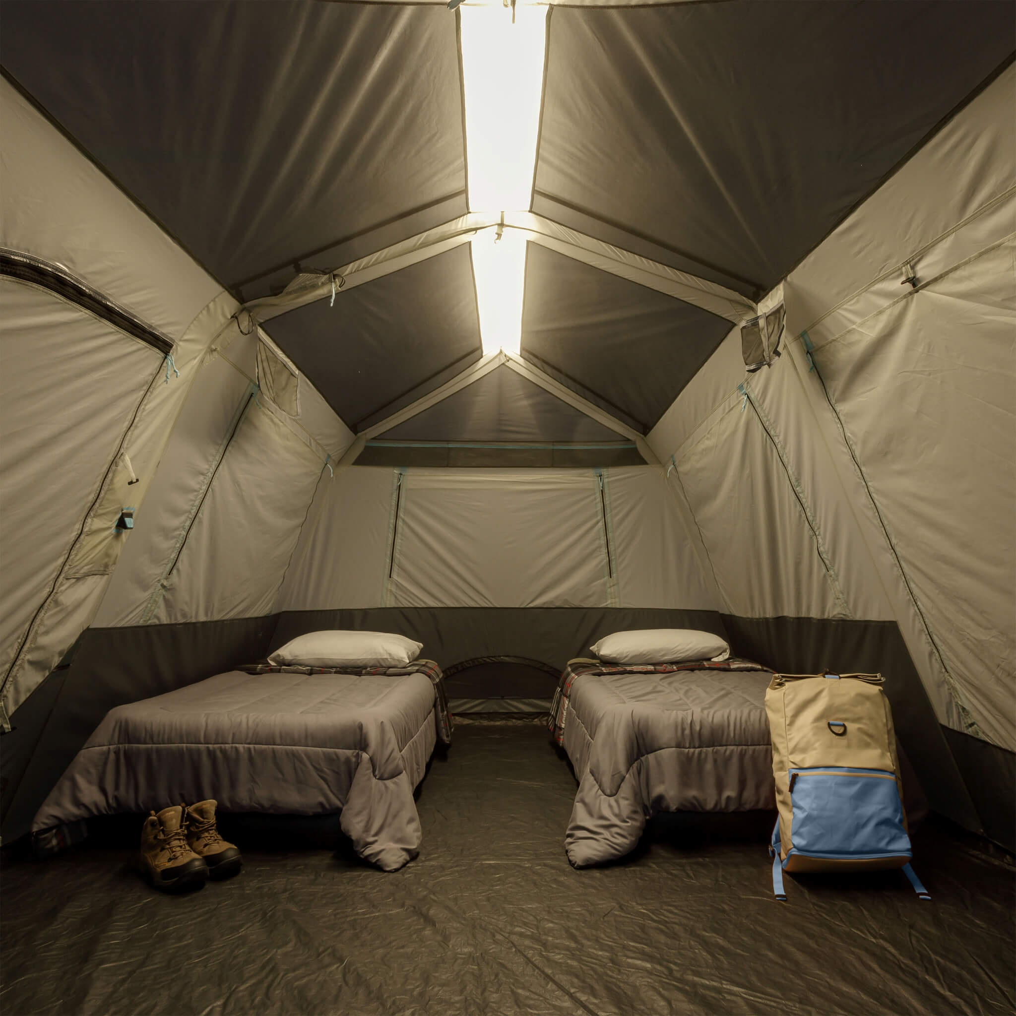 Inside CORE 10 person lighted instant cabin tent with air mattresses, showing overhead light bar on high for nighttime visibility and comfort.