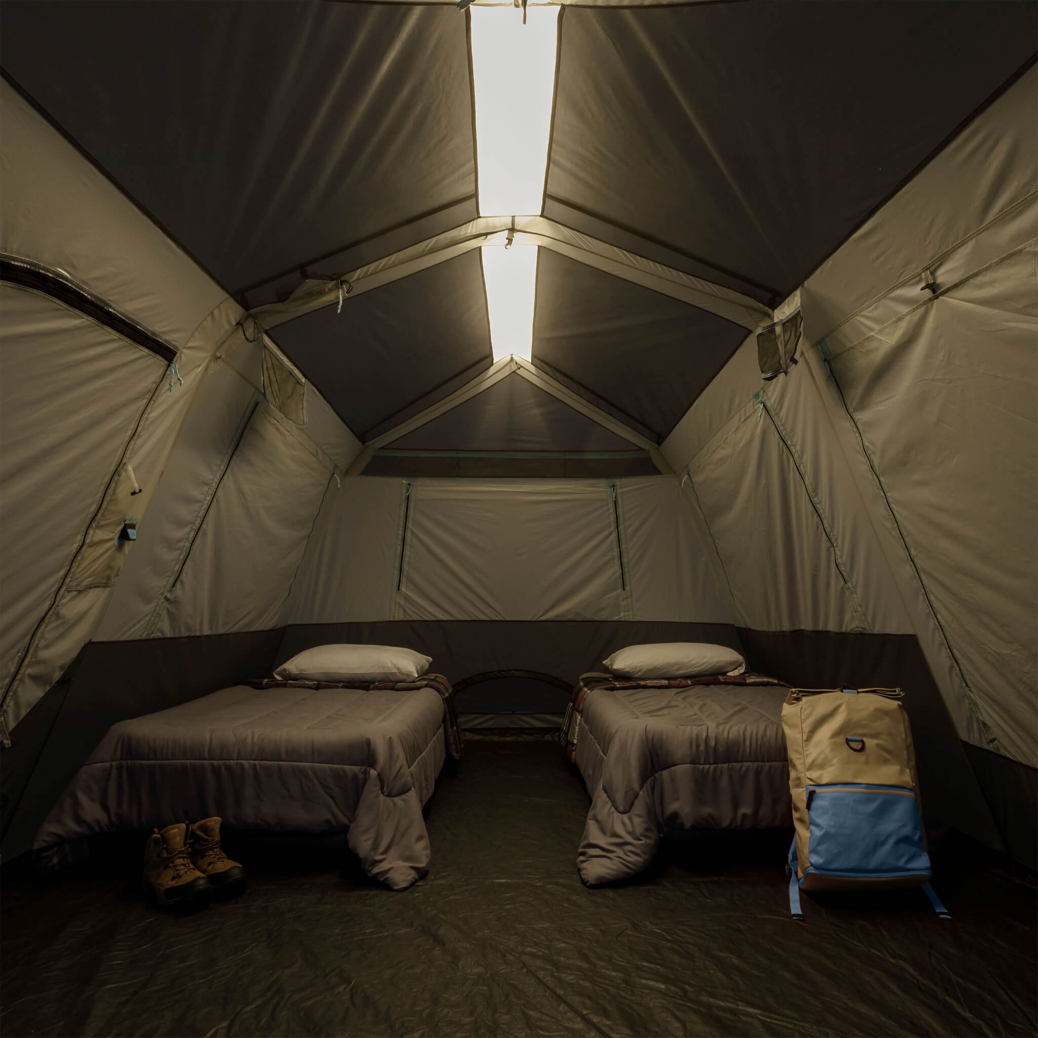 Inside CORE 10 person lighted instant cabin tent with air mattresses, showing overhead light bar on low for nighttime visibility and comfort.