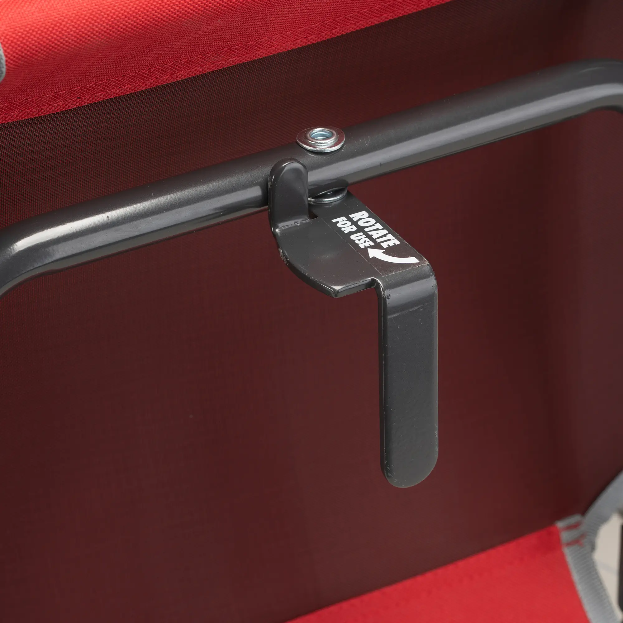 An up-close of the l-hook underneath the red big comfort stadium chair with armrests. 