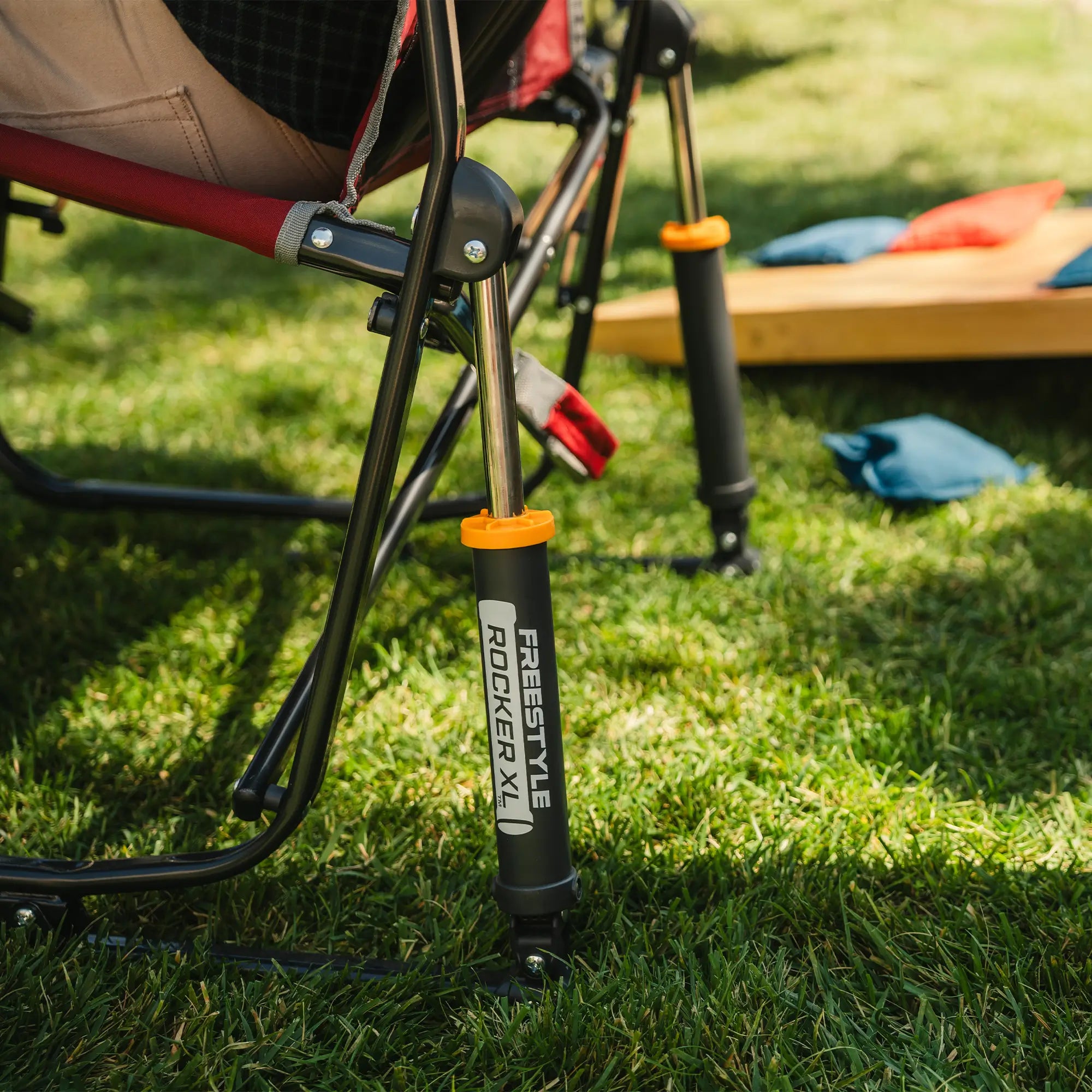 Up-close of the spring action rocking technology on a red freestyle rocker with side table. 