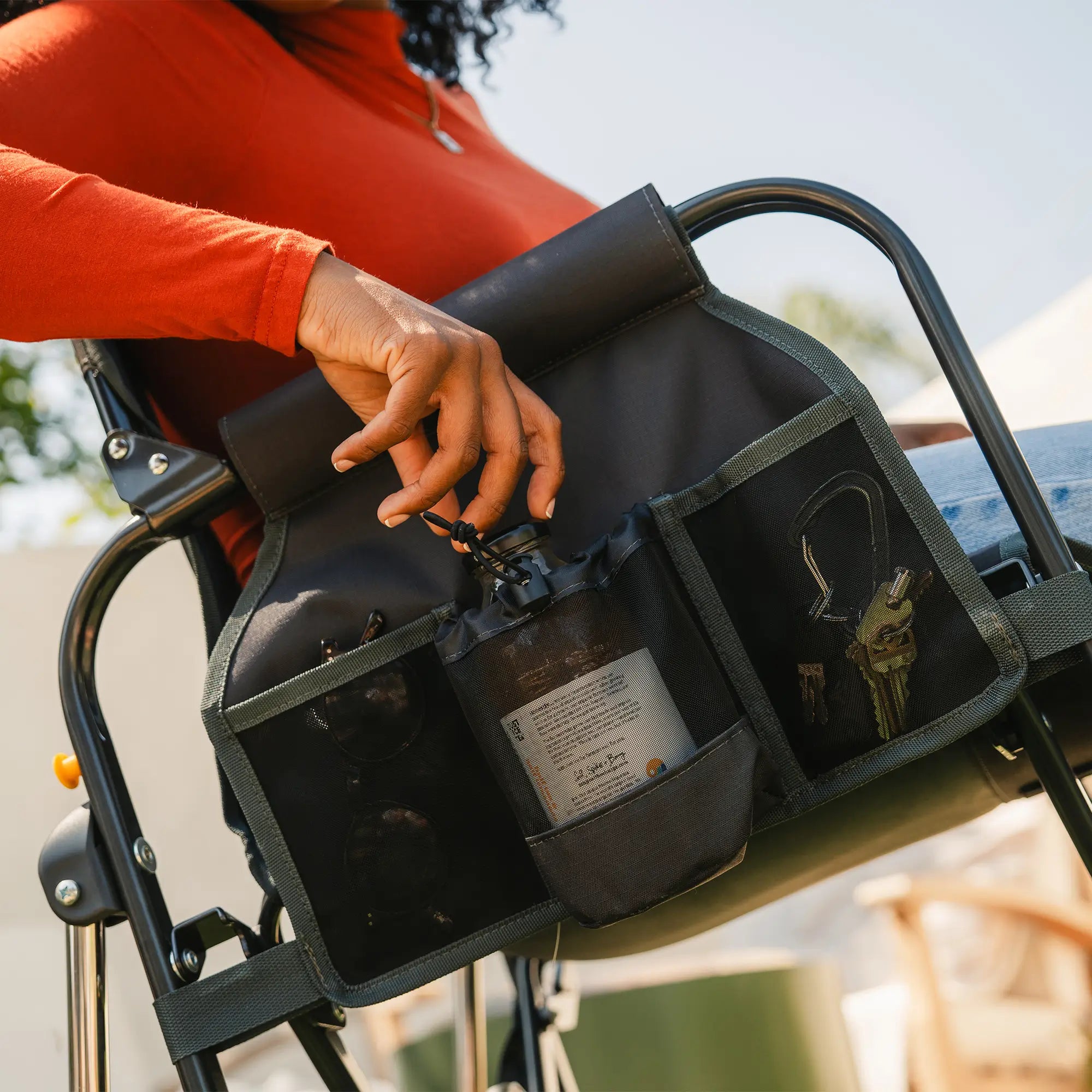An up-close angle of the side pocket on the gray tailgater stowaway rocker showing a phone pocket and drink holder. 