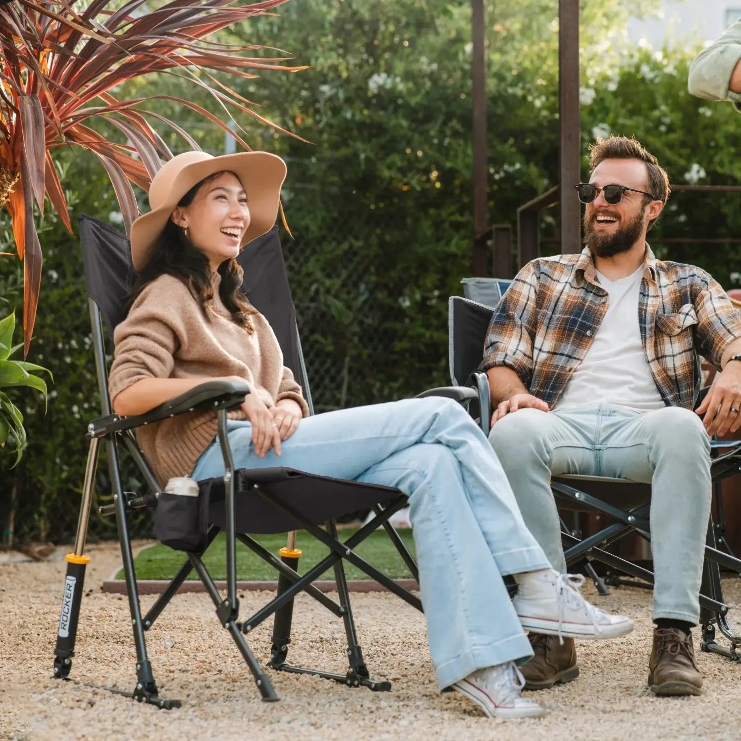 Woman smiles while lounging in dark charcoal Roadtrip Rocker with drink holder.